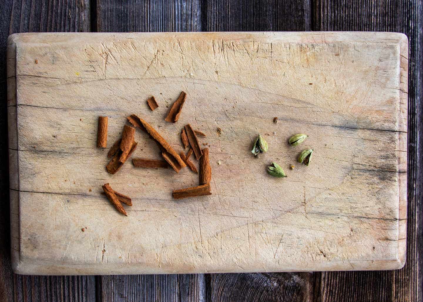 Smashed cinnamon and cardamom on cutting board