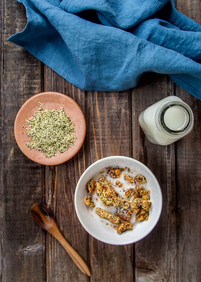 Hemp hearts in plate, with granola and hemp milk in bowl