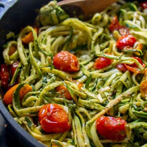 Ingredients for zucchini noodle pesto pasta with tomatoes in frying pan