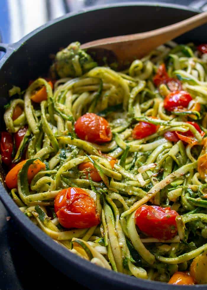 Ingredients for zucchini noodle pesto pasta with tomatoes in frying pan