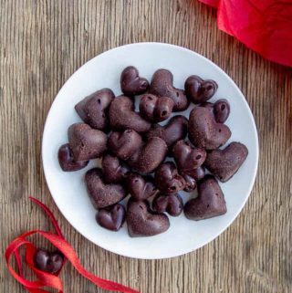 Raw Chocolate Hearts on White Plate on Wooden Background