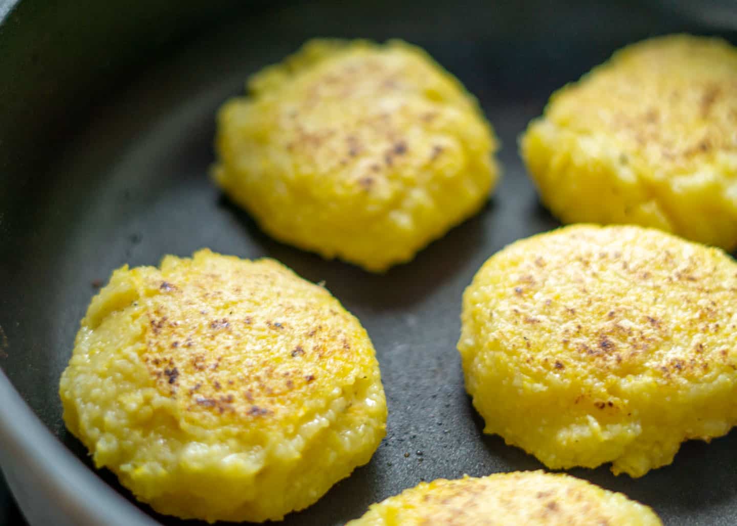 Flipped corn patties in frying pan