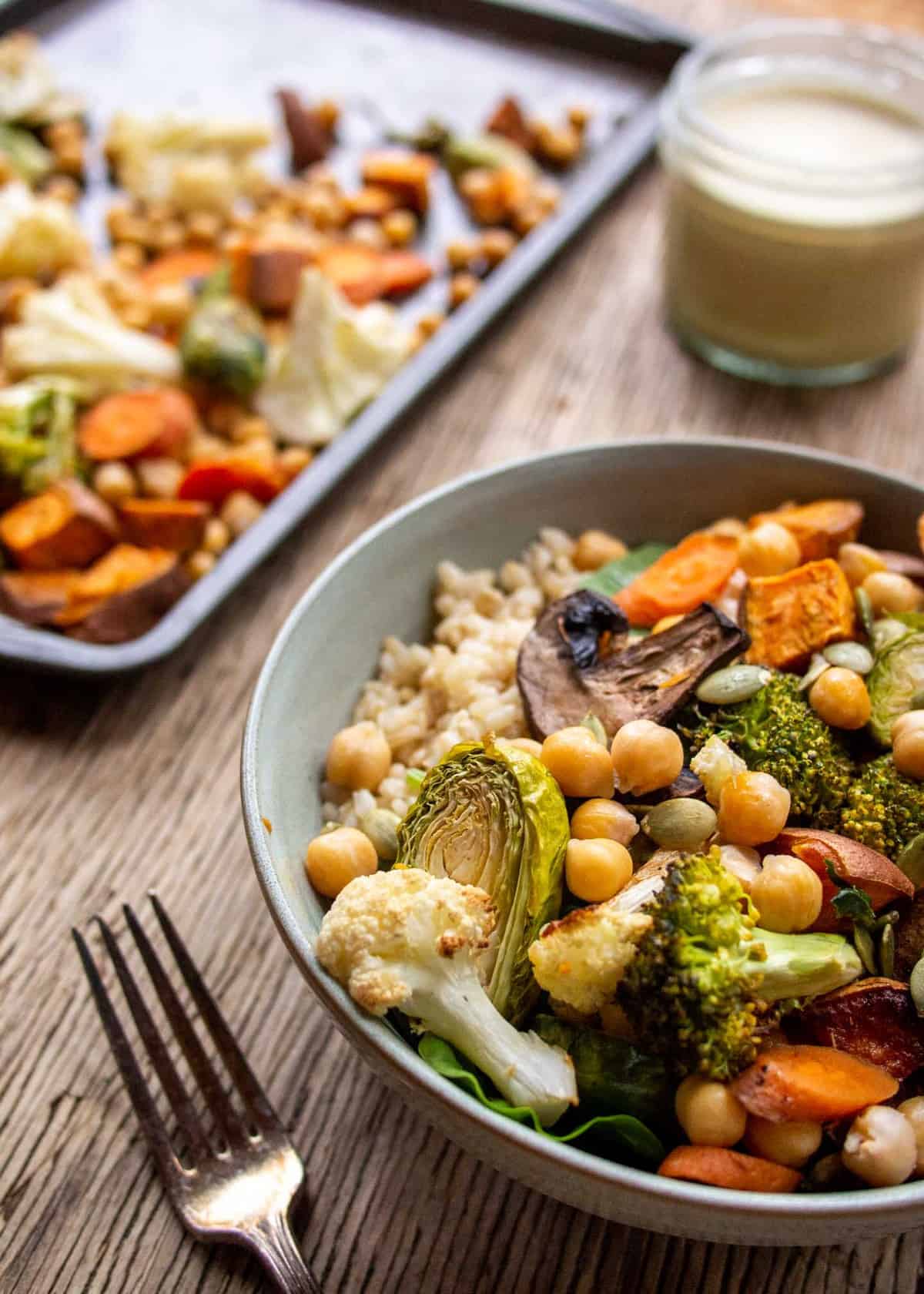 bowl of roasted vegetables with baking tray in back