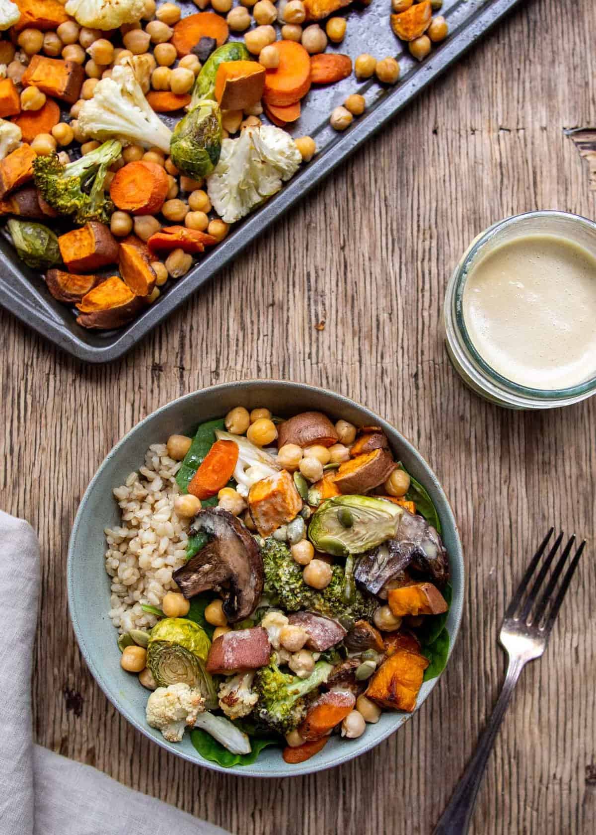 Roasted vegetables in blue bowl with baking tray on side